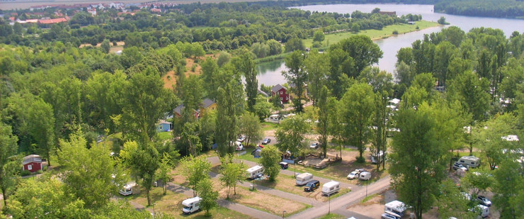 Wohnmobilplatz aus der Luft am Hainer See, viele grüne Bäume und dazwischen vereinzelte Wohnmobile