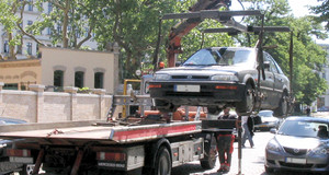 Ein ordnungswidrig geparktes Auto auf einen Abschleppwagen gehoben
