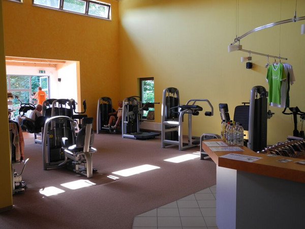 Fitnessraum mit verschiedenen Sportgeräten zum Fitnesstraining.