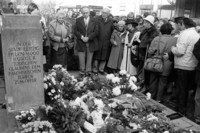 Schwarz-Weiß-Foto von 1992 mit ehemaligen jüdischen Leipzigern die Blumen vor einen Gedenkstein für die ermordeten jüdischen Leipzigern niedergelegt haben.