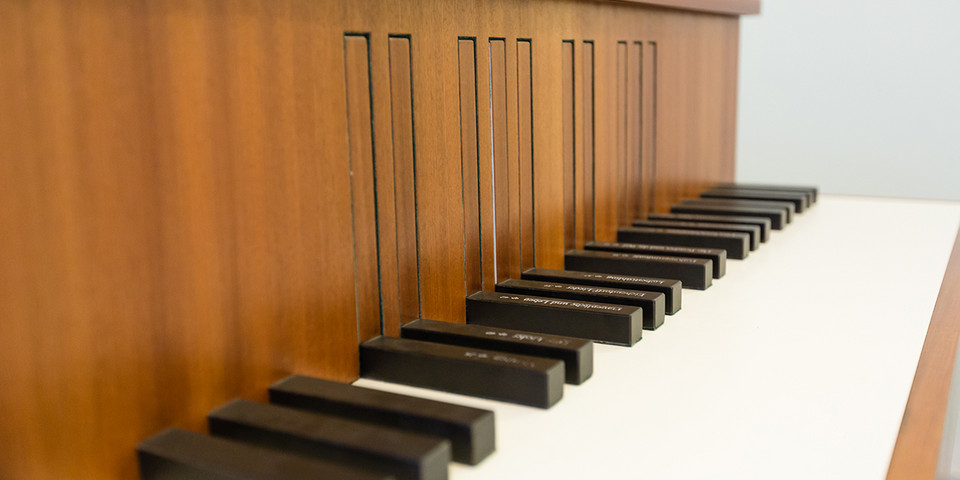 Nahaufnahme der Tastatur eines Klaviers aus braunem Holz