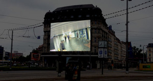 Auf einer Hausfassade projiziertes Bild einer Überwachungskamera