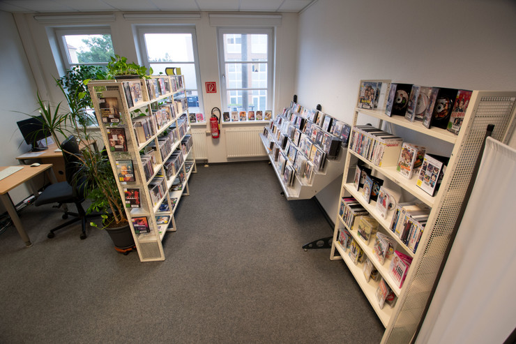 Bibliotheksbereich mit Regalen für DVDs, Musik CDs und Hörbüchern.