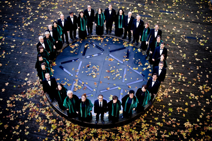Die Mitglieder des Leipziger Synagogalchors stehen, in schwarzgrünen Roben im Kreis um einen Davidstern herum.