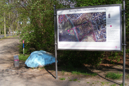 Hinweisschild zum Telekom Running Track in einem Park