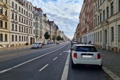 Georg-Schumann-Straße mit an der Seite parkenden Autos und Häusern.