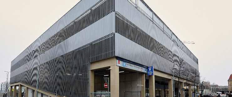 Außenansichtansicht des Fernbusterminals Hauptbahnhof. Funktionales Gebäude mit metallener Außenverkleidung und einer Einfahrt zu einem Parkhaus.