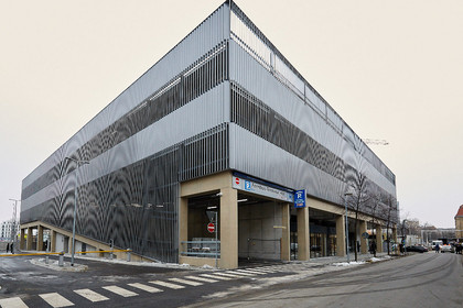 Außenansichtansicht des Fernbusterminals Hauptbahnhof. Funktionales Gebäude mit metallener Außenverkleidung und einer Einfahrt zu einem Parkhaus.