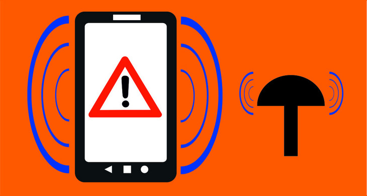 Links im Bild ein Smartphone mit Warnschild "Achtung" auf dem Display, umgeben von angedeuteten Schallwellen. Recht im Bild eine stilisierte Sirene, umgeben von angedeuteten Schallwellen. Die Hintergrund ist orange.
