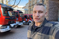 Vitali Klitschko steht vor neuen Feuerwehrfahrzeugen in Kiew.