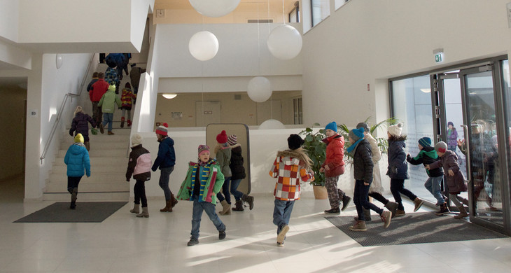 Eine Gruppe Kinder läuft durch den Eingangsbereich einer Schule.