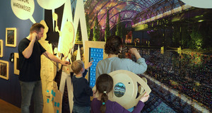 Familie schaut sich eine Ausstellung zur Leipziger Messe im Kindermuseum Leipzig an