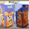 Abfallbehälter mit Graffiti-Motiv, oranges Müllmonster auf blauen Untergrund
