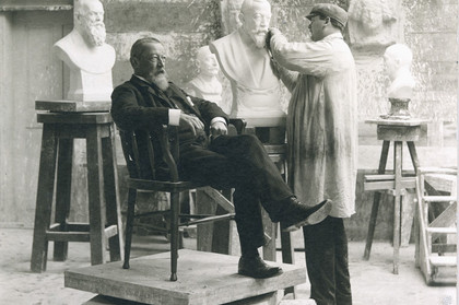 links Hugo Licht im Profil sitzend, mittig weiße Büste von Licht, rechts Bildhauer Georg Wrba mit Arbeitsmaterial.