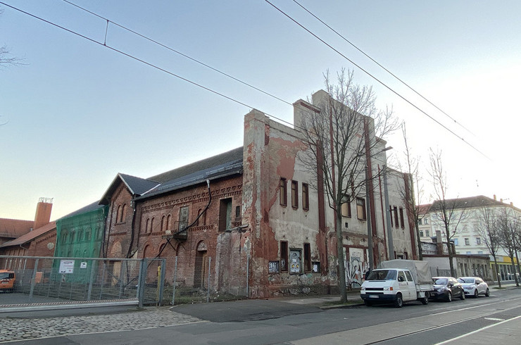 Ein großes, altes Ziegelsteingebäude in der Eisenbahnstraße 162, dessen Fenster vernagelt sind. Der Putz an der Fassade zur Straßenseite ist an vielen Stellen abgebröckelt.