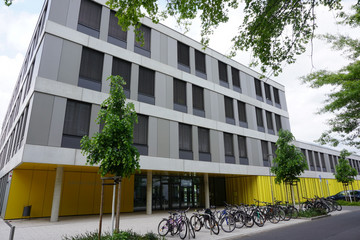 Der Gebäudebereich der Sportoberschule mit dem Eingang ist im Erdgeschoss gelb gestaltet, die Fassade der drei darüber liegenden Etagen ist weiß und grau.