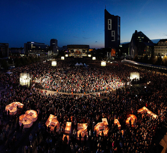 Blick über den Augustusplatz mit tausenden Besuchern und dem erleuchteten Schriftzug "Leipzig 89".