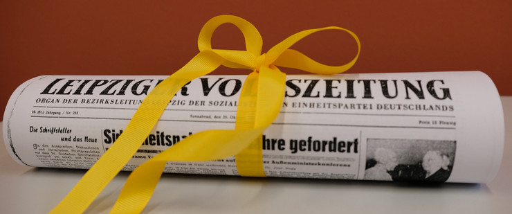 Kopie der Leipziger Volkszeitung, eingerollt mit gelbem Schleifenband