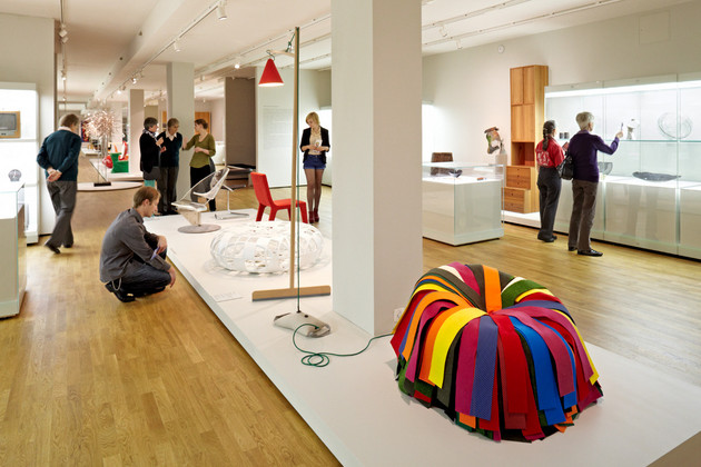 Viele Besucher in einem Ausstellungsraum mit Kunstobjekten.