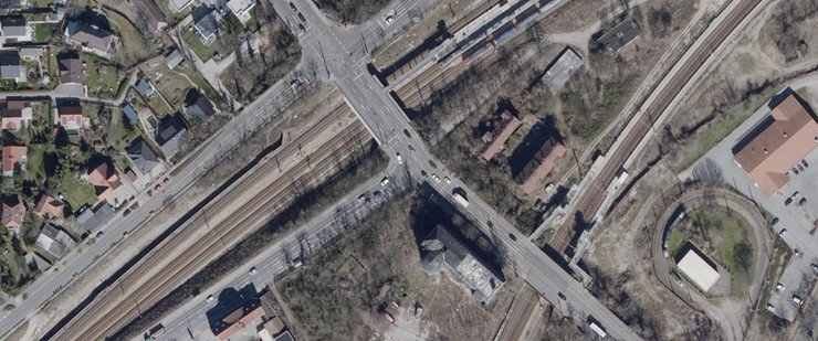 Ein Luftbild einer mehrspurigen Straße, die mit zwei Brücken über Bahngleise führt