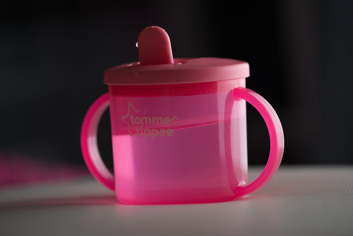 Eine rosa Babytrinkflasche mit Griffen an den Seiten und Mundstück