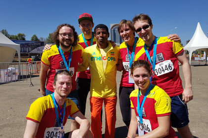 Gruppenfoto von Damen und Herren in Sportsachen in den Farben gelb, rot und grün, welche die Staatsfarben Äthiopiens darstellen