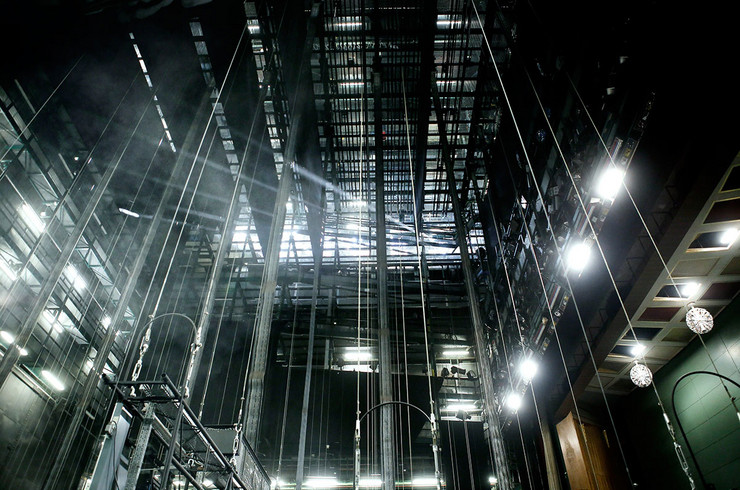 Dunkler Raum mit vielen Drahtseilen, die von der rund zehn Meter hohen Decke hängen