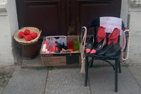 Ausrangierte Gegenstände wie Schuhe, ein Stuhl und eine Kiste mit Büchern stehen vor der Haustür