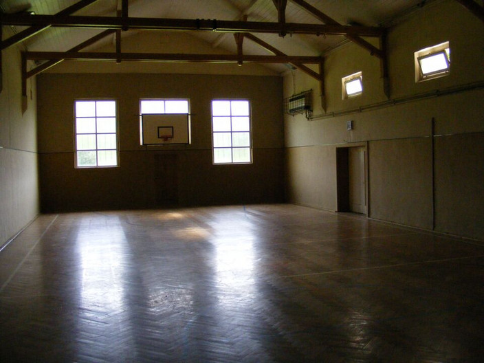 Innenraum der Sporthalle mit einem Basketballkorb