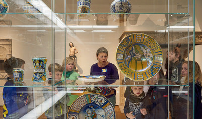 Jugendliche hinter einer Glasvitrine mit bemalten historischen Keramiktellern im Grassi Museum für Angewandte Kunst