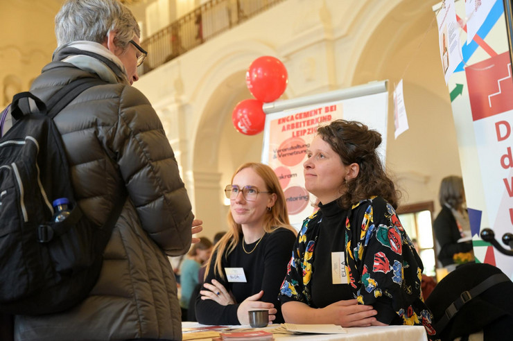 drei Personen unterhalten sich an einem Informationsstand zu Engagementmesse 2023 in Leipzig