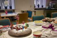 Ein Tisch mit Kuchen, Cakepops, bunten Bechern und Servietten