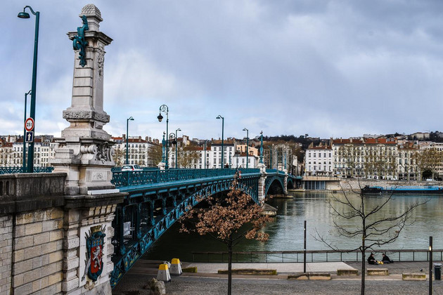 Steinerne Brücke mit historischem Wappen und blau-grüner Flussüberquerung aus Metall