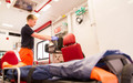 Ein Mann hantiert in einem Rettungswagen an einem medizinischen Gerät.