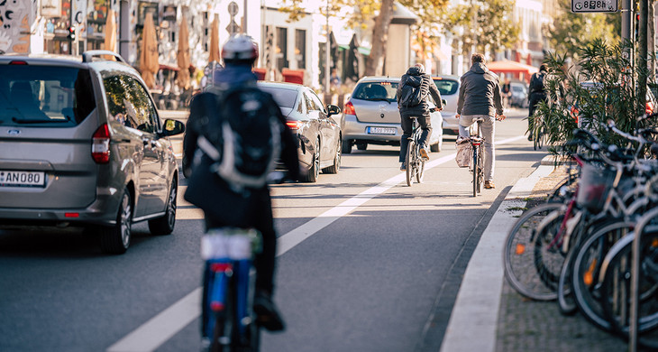 Fahrradfahrer auf einem Radfahrstreifen und Autos auf einer Straße in Leipzig