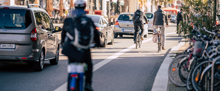Fahrradfahrer auf einem Radfahrstreifen und Autos auf einer Straße in Leipzig