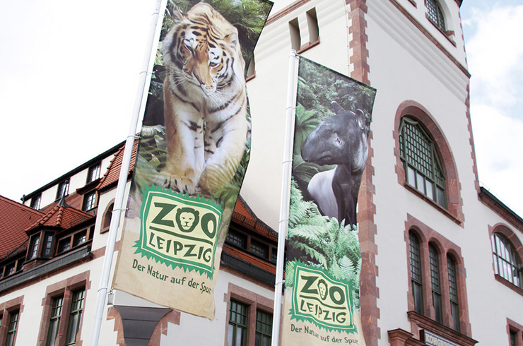 Eingangsbereich im Zoo mit wehenden Bannern "Zoo der Zukunft"