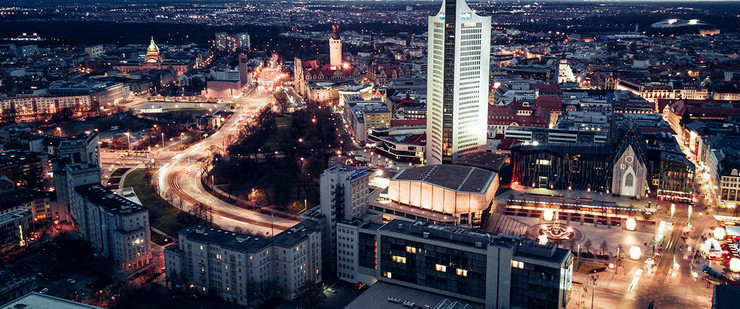 Leipzig Stadtansicht abends mit Cityhochhaus und beleuchteten Straßen