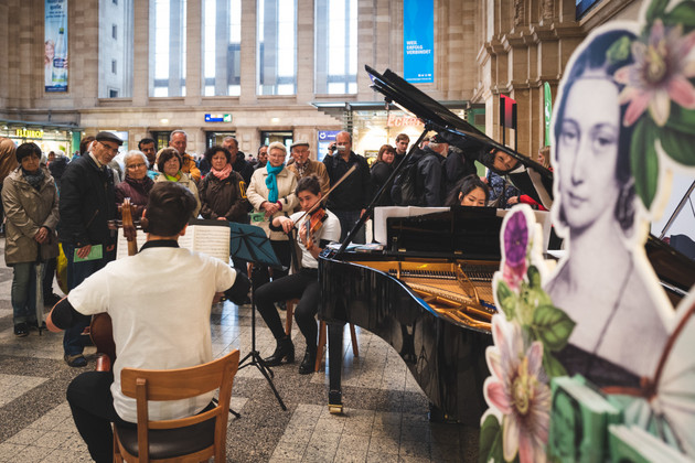 Cellist, Geigerin und Pianistin vor Publikum im Hauptbahnhof