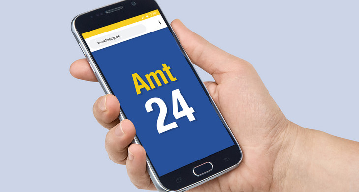 Eine Hand hält ein Smartphone, auf dem Bildschirm ist zu lesen "Amt 24".