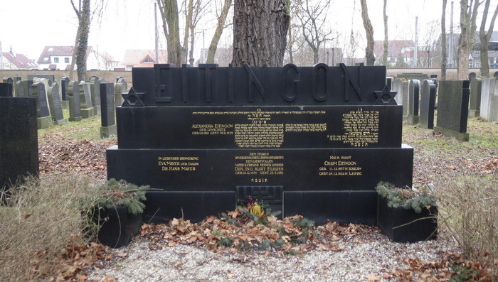 Bild des neuen jüdischen Friedhofs mit verschiedenen Grabsteinen. In der Mitte ist ein sehr großer mit vielen Inschriften.
