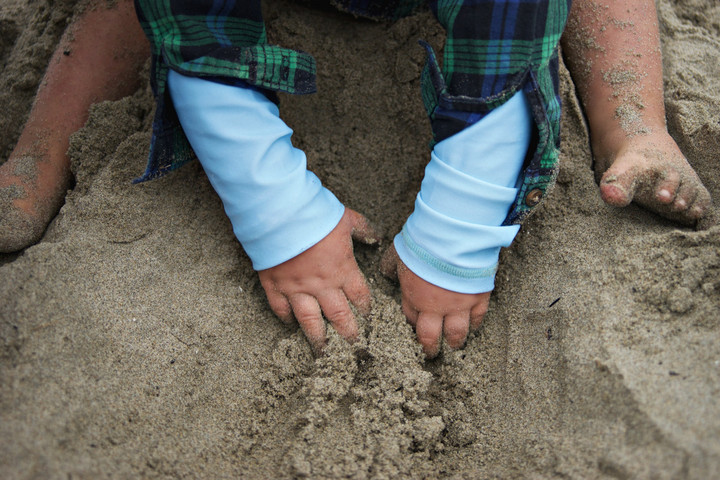 Kinderhände graben im Sand