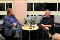 Gespräch vor Publikum in der Bibliothek, an einem runden Tisch sitzen Moderator Volly Tanner rechts und Gast Bastian Salier links