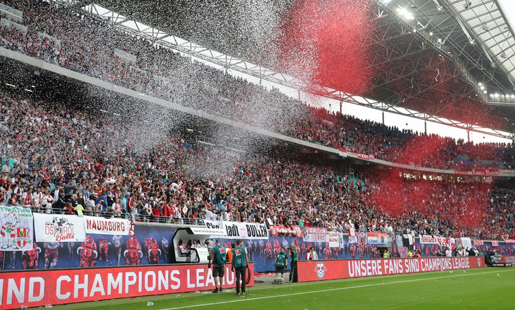 Zu sehen ist der Fanblock von RB Leipzig in der Red Bull Arena Leipzig. Es regnet rotes und weißes Konfetti.