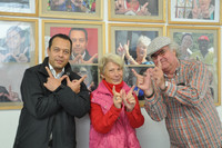 3 Menschen zeigen mit Ihren Händen ein Willkommens-W vor ihren Porträts
