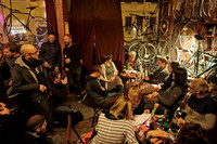 Eine kultige Bar mit vielen Fahrrädern an den Wänden. Wolf Schmid liest im Kreis von Zuhörern aus seinem Buch vor.