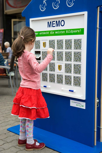 Ein Kind spielt an einem Memory auf dem Markt Leipzig