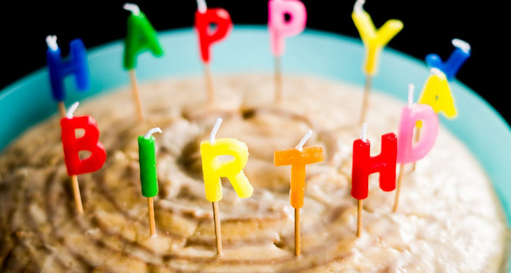 Geburtstagskuchen mit bunten Happy-Birthday-Kerzen
