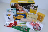 Das Leipziger Baby-Startpaket und sein Inhalt sind auf einem Tisch ausgebreitet. Mehrere kleine Geschenke wie zum Beispiel ein Babykalender, ein Badethermometer oder Babysöckchen sind zu sehen.