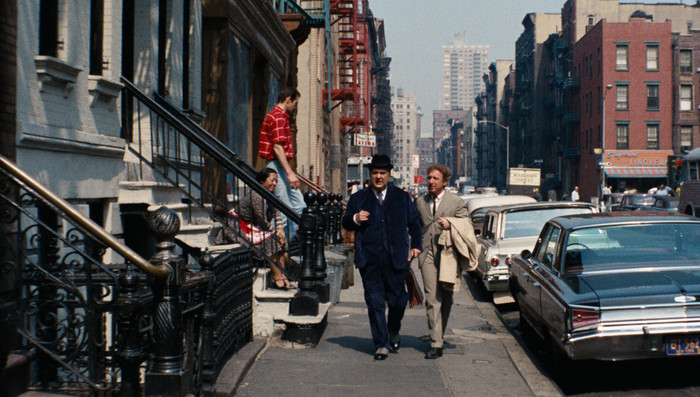 Nicholas Cage und ein Mann im Anzug gehen eine Straße entlang